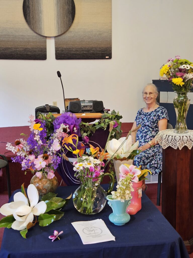 Vases of flowers and service leader from 2023 Flower Communion